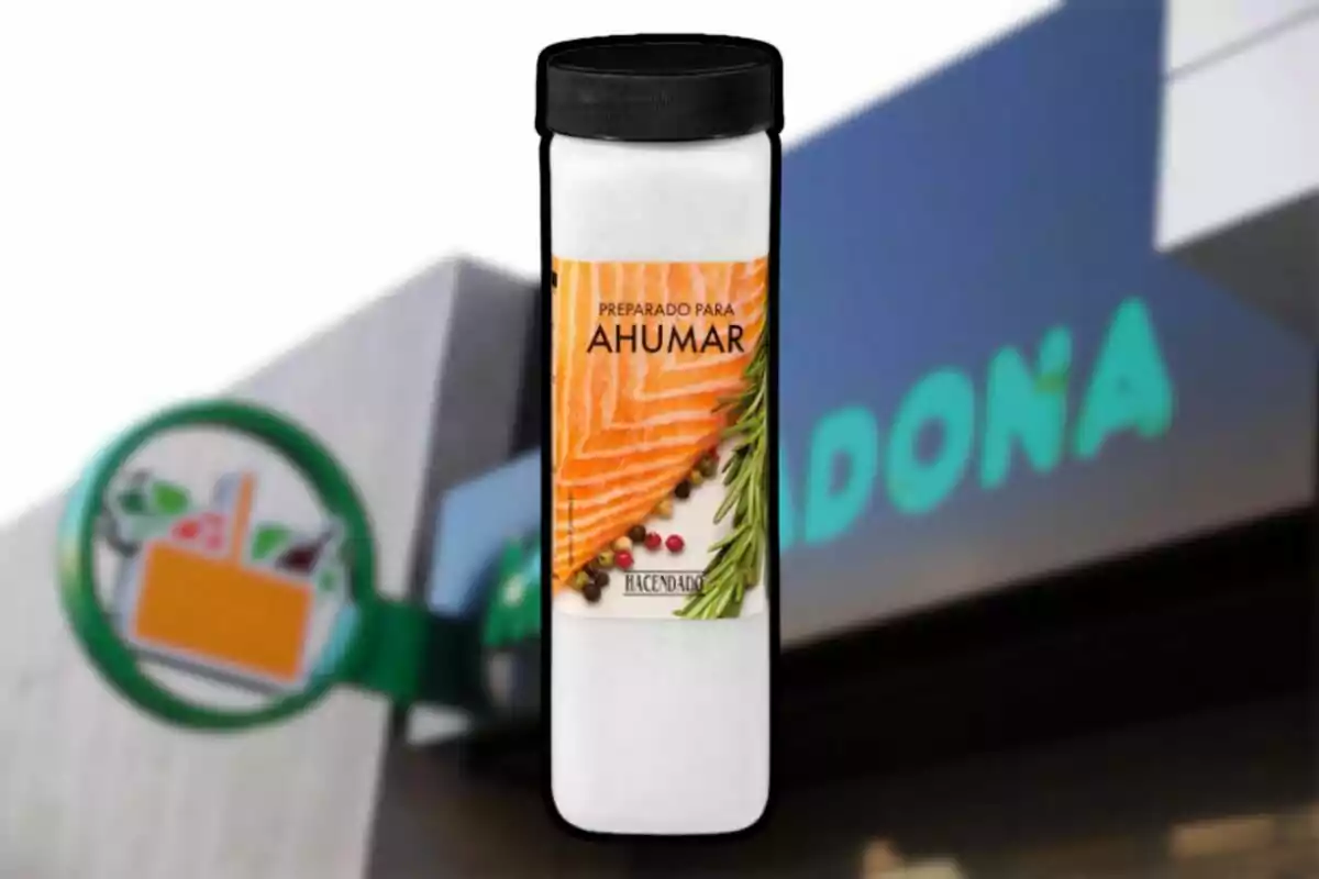 Bote de preparado para ahumar de la marca Hacendado frente a una tienda Mercadona desenfocada Bote de preparado para ahumar de la marca Hacendado frente a una tienda Mercadona desenfocada