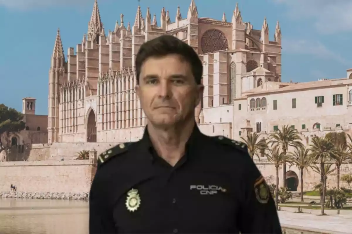 Un policía con uniforme de la Policía Nacional de España posando frente a la catedral de Palma de Mallorca en un día soleado.