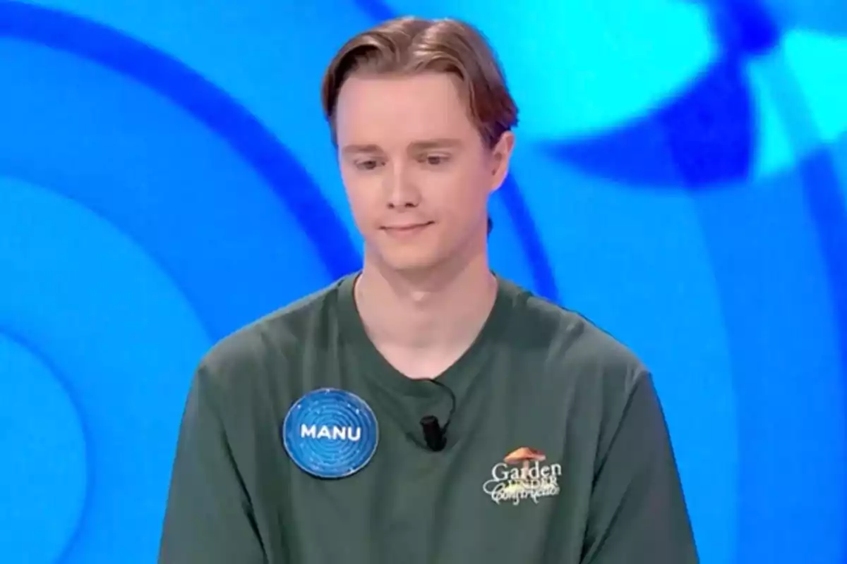 Manu con camiseta verde y placa identificativa en un programa de televisión con fondo azul. Captura de 'Pasapalabra' Manu con camiseta verde y placa identificativa en un programa de televisión con fondo azul. Captura de 'Pasapalabra'
