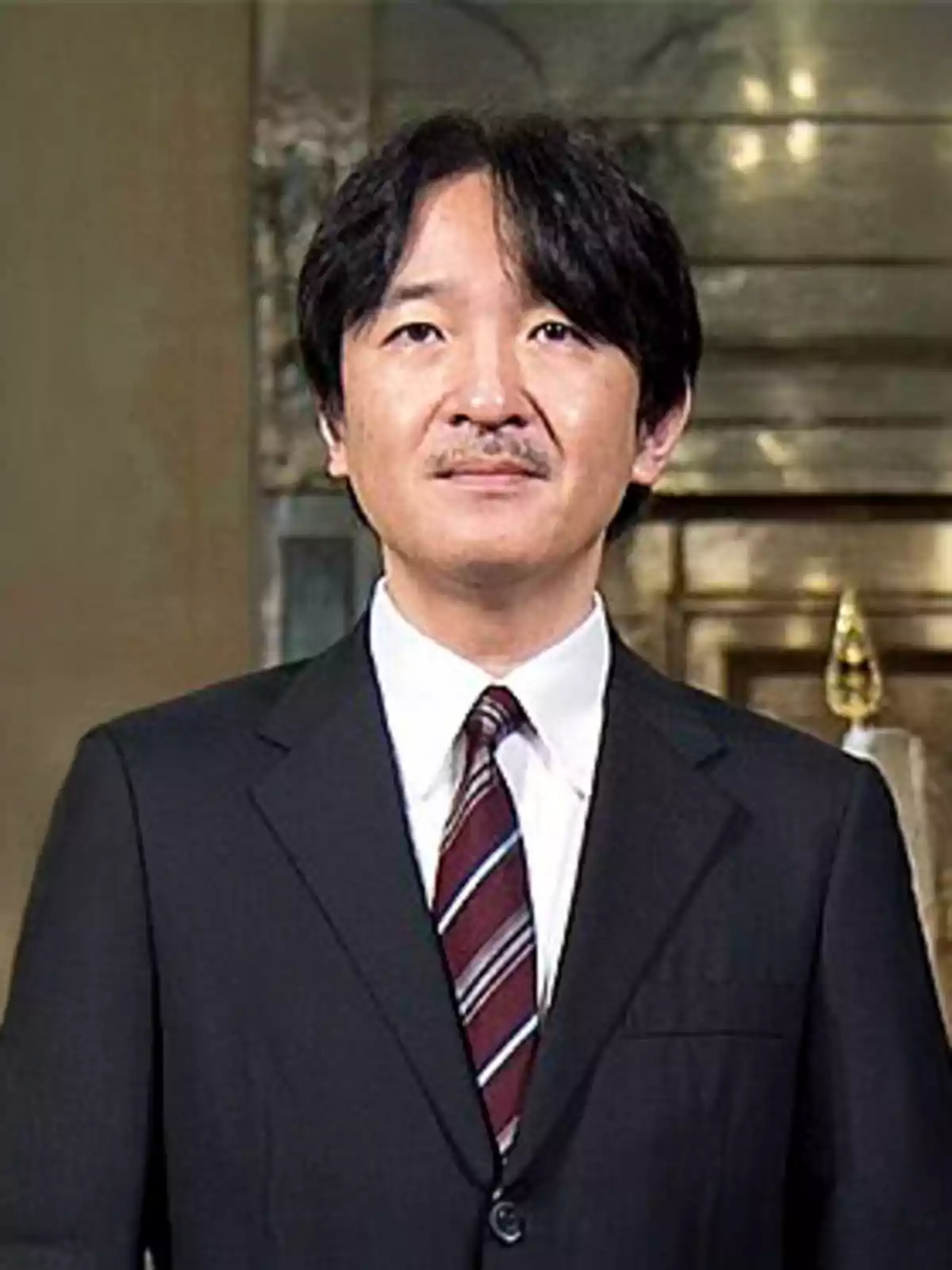 Hombre de cabello oscuro y bigote vistiendo traje formal con corbata a rayas en un entorno elegante Hombre de cabello oscuro y bigote vistiendo traje formal con corbata a rayas en un entorno elegante