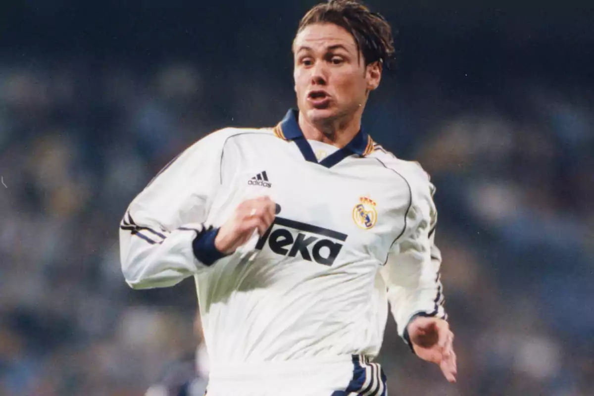 Futbolista con uniforme blanco del Real Madrid corriendo en el campo durante un partido Futbolista con uniforme blanco del Real Madrid corriendo en el campo durante un partido