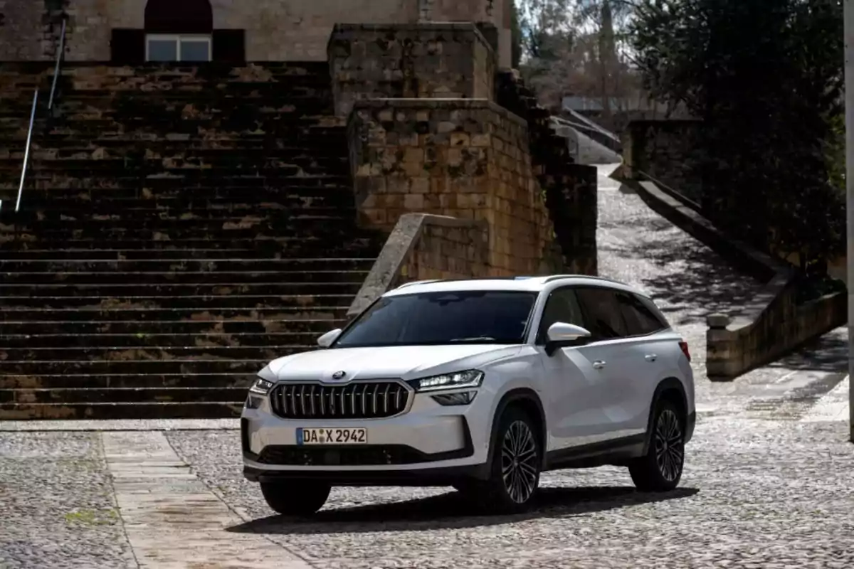 SUV blanco estacionado frente a una escalera de piedra en un entorno urbano antiguo SUV blanco estacionado frente a una escalera de piedra en un entorno urbano antiguo