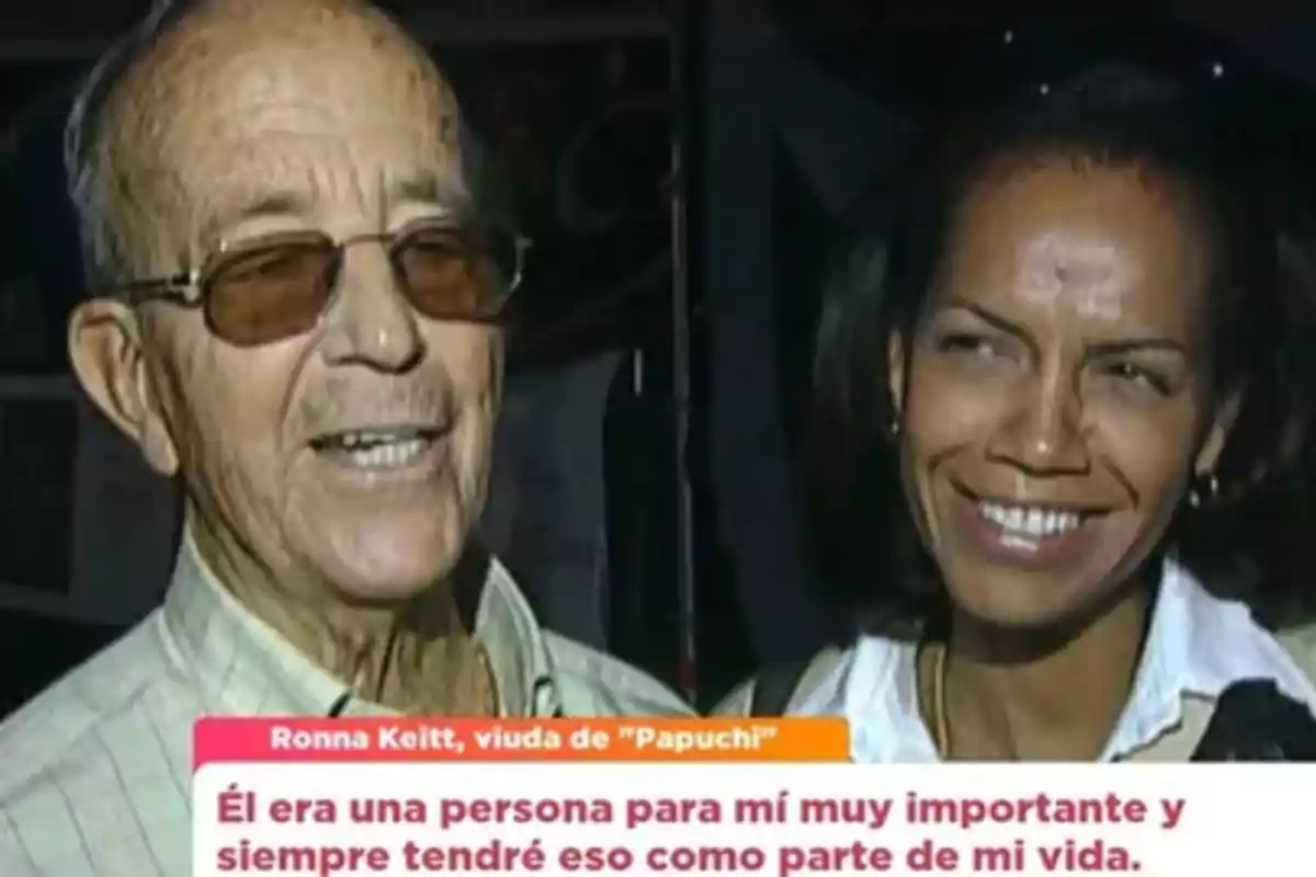 Un hombre mayor con gafas y una mujer sonriente posan juntos mientras aparece un recuadro con texto en la parte inferior de la imagen. Un hombre mayor con gafas y una mujer sonriente posan juntos mientras aparece un recuadro con texto en la parte inferior de la imagen.