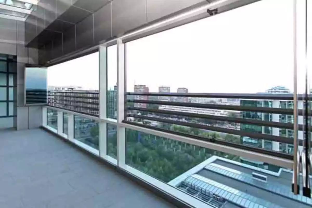 Terraza moderna con barandales de metal y vista a edificios y áreas verdes en una ciudad Terraza moderna con barandales de metal y vista a edificios y áreas verdes en una ciudad