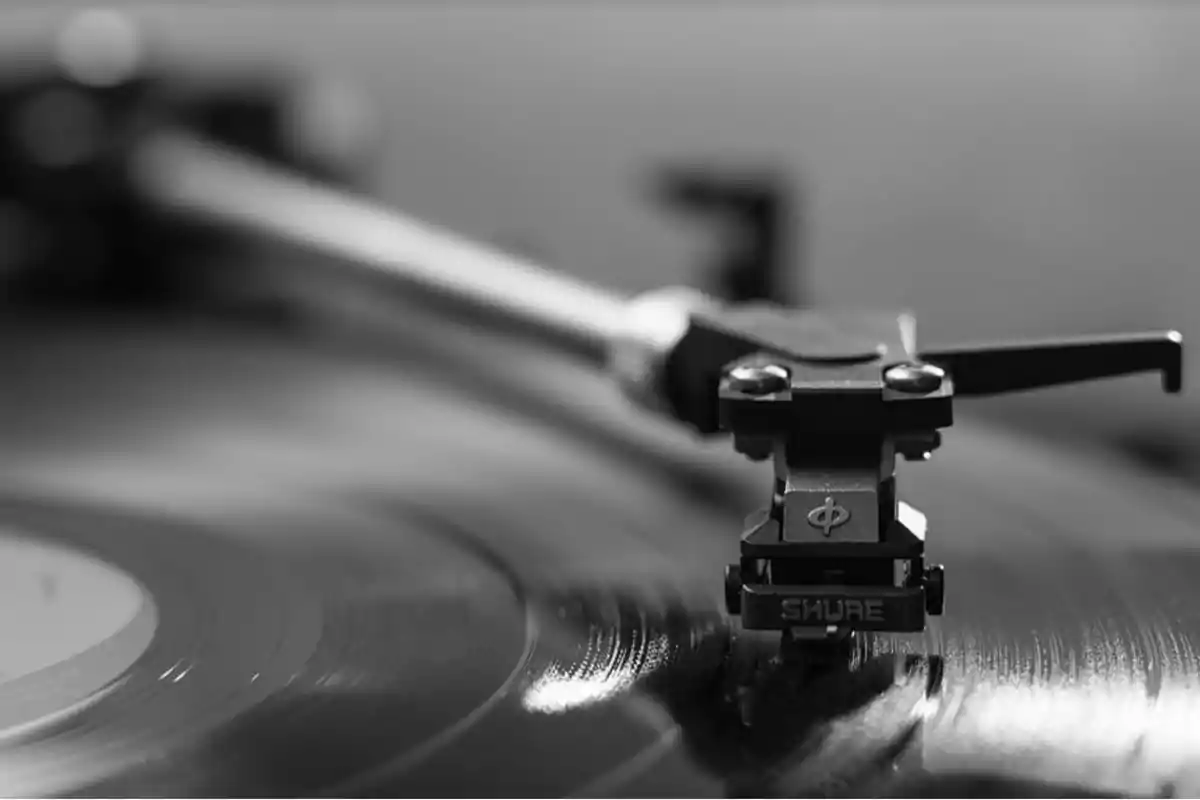 Brazo de tocadiscos reproduciendo un vinilo en primer plano en blanco y negro Brazo de tocadiscos reproduciendo un vinilo en primer plano en blanco y negro