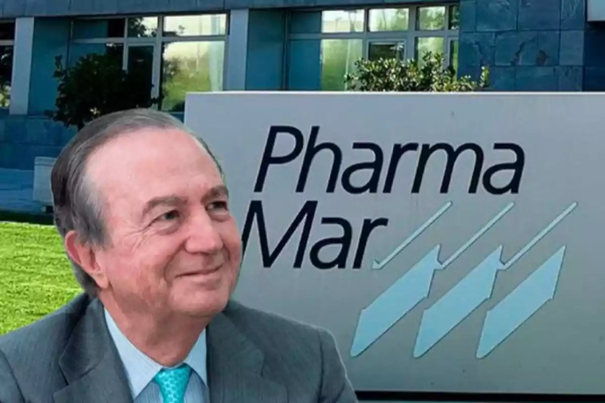 Hombre mayor sonriente con traje frente a un cartel de la empresa PharmaMar