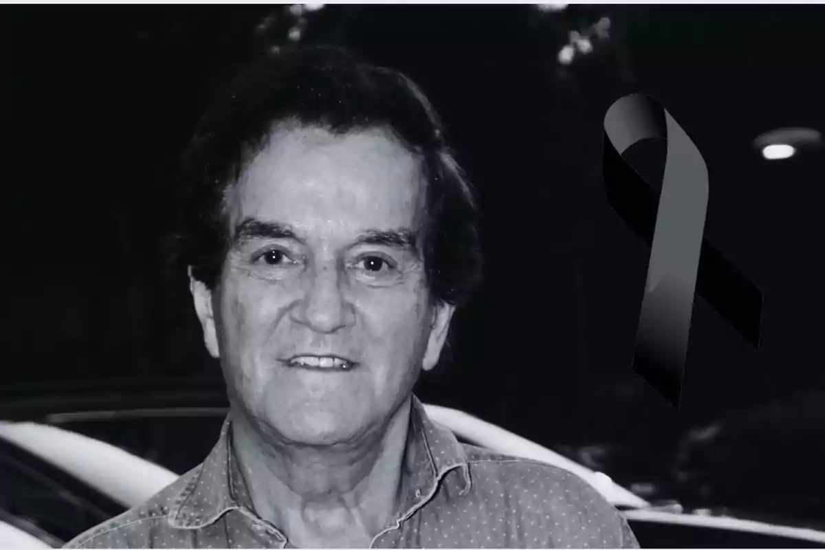 Hombre mayor sonriente en una foto en blanco y negro con un moño negro de luto a la derecha