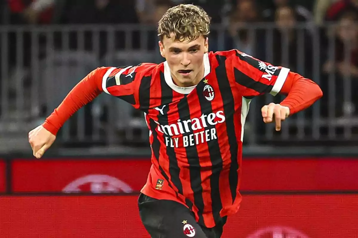 Futbolista con uniforme del AC Milan corriendo en el campo durante un partido Futbolista con uniforme del AC Milan corriendo en el campo durante un partido