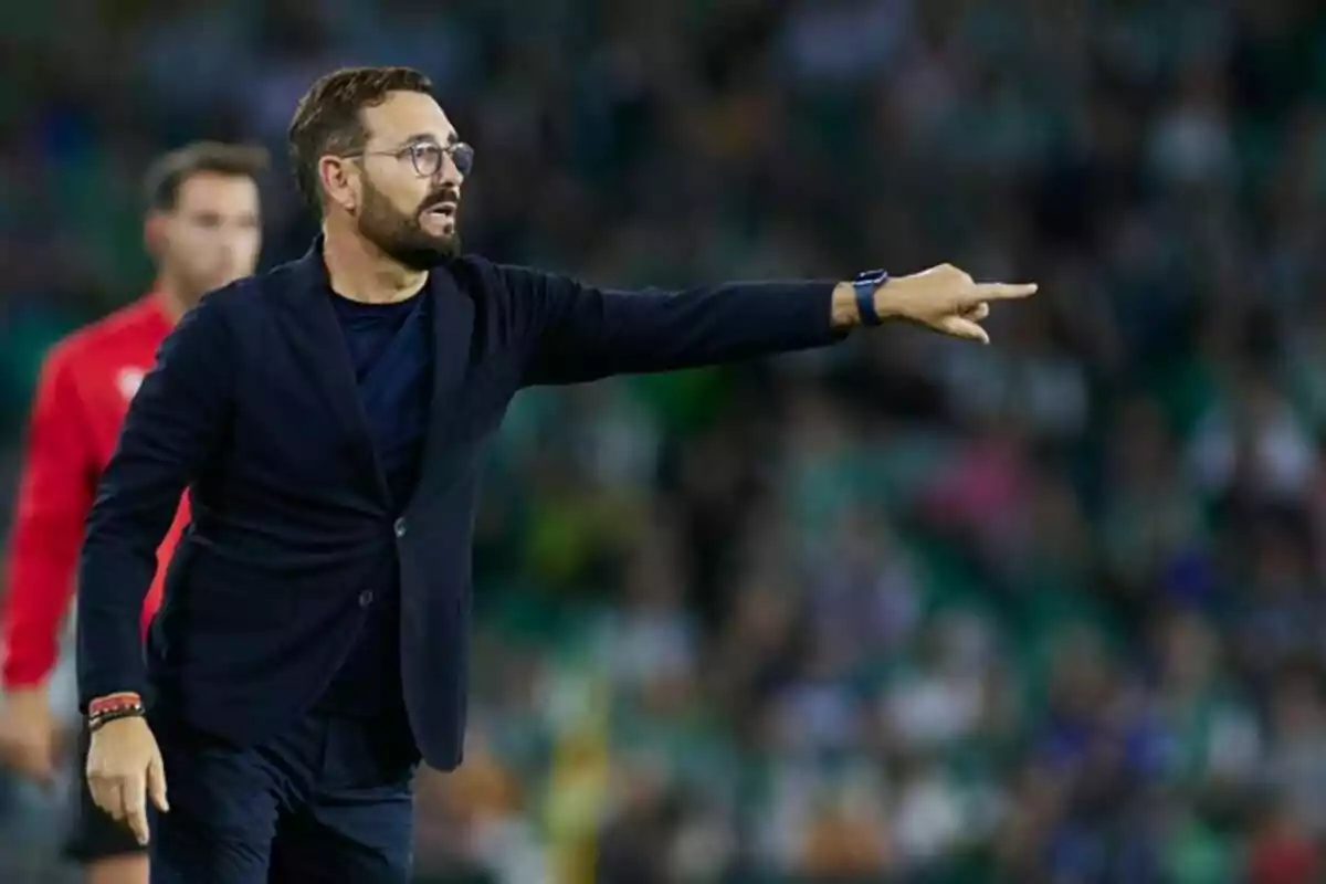 Entrenador de fútbol dando indicaciones en la banda durante un partido Entrenador de fútbol dando indicaciones en la banda durante un partido