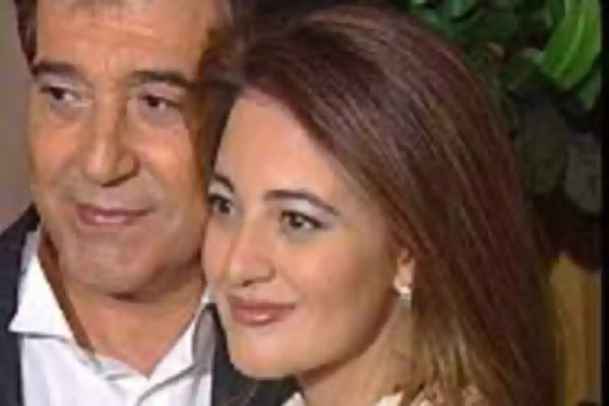 Un hombre y una mujer posan juntos y sonríen frente a la cámara Un hombre y una mujer posan juntos y sonríen frente a la cámara