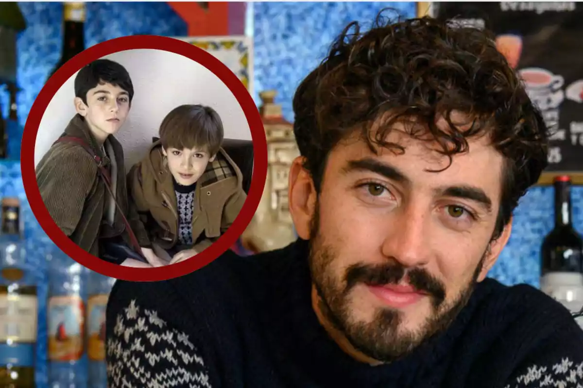 Hombre de cabello rizado y barba con suéter oscuro, al fondo botellas y una pared azul, en la esquina superior izquierda un círculo muestra a dos niños sentados mirando a la cámara.