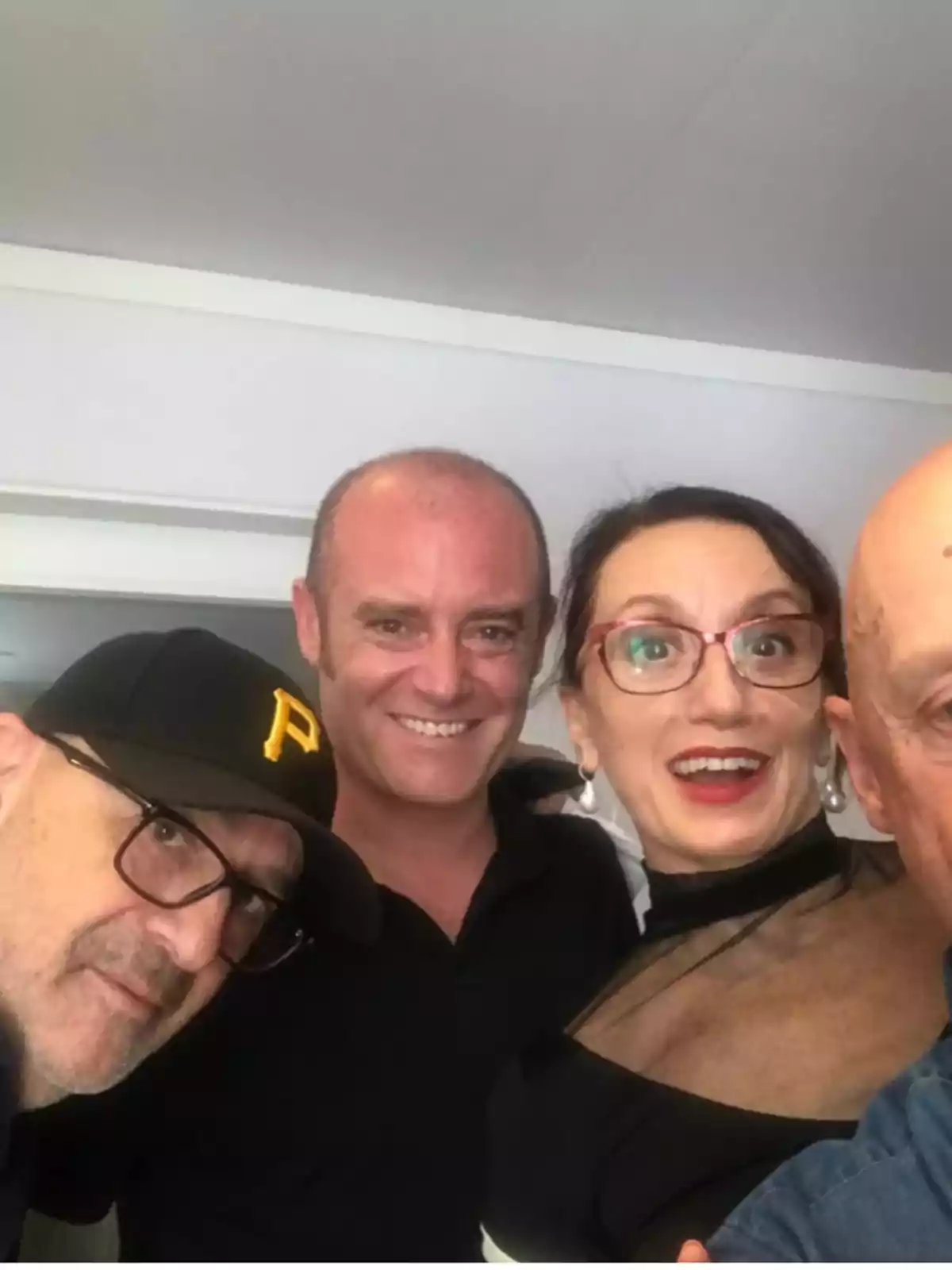 Cuatro personas posan juntas para una selfie en un ambiente interior, todos lucen sonrientes y relajados Cuatro personas posan juntas para una selfie en un ambiente interior, todos lucen sonrientes y relajados