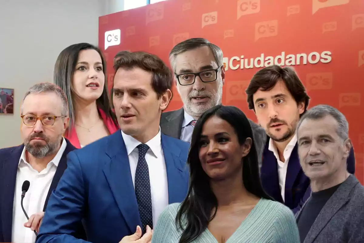Un grupo de personas posando frente a un fondo rojo con el logo y nombre de Ciudadanos