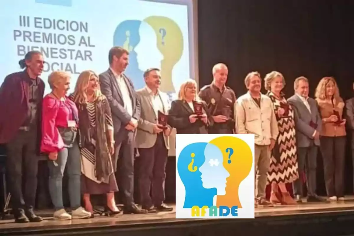 Grupo de personas en un escenario recibiendo premios al bienestar social con un cartel de fondo y el logo de AFAIDE en primer plano Grupo de personas en un escenario recibiendo premios al bienestar social con un cartel de fondo y el logo de AFAIDE en primer plano