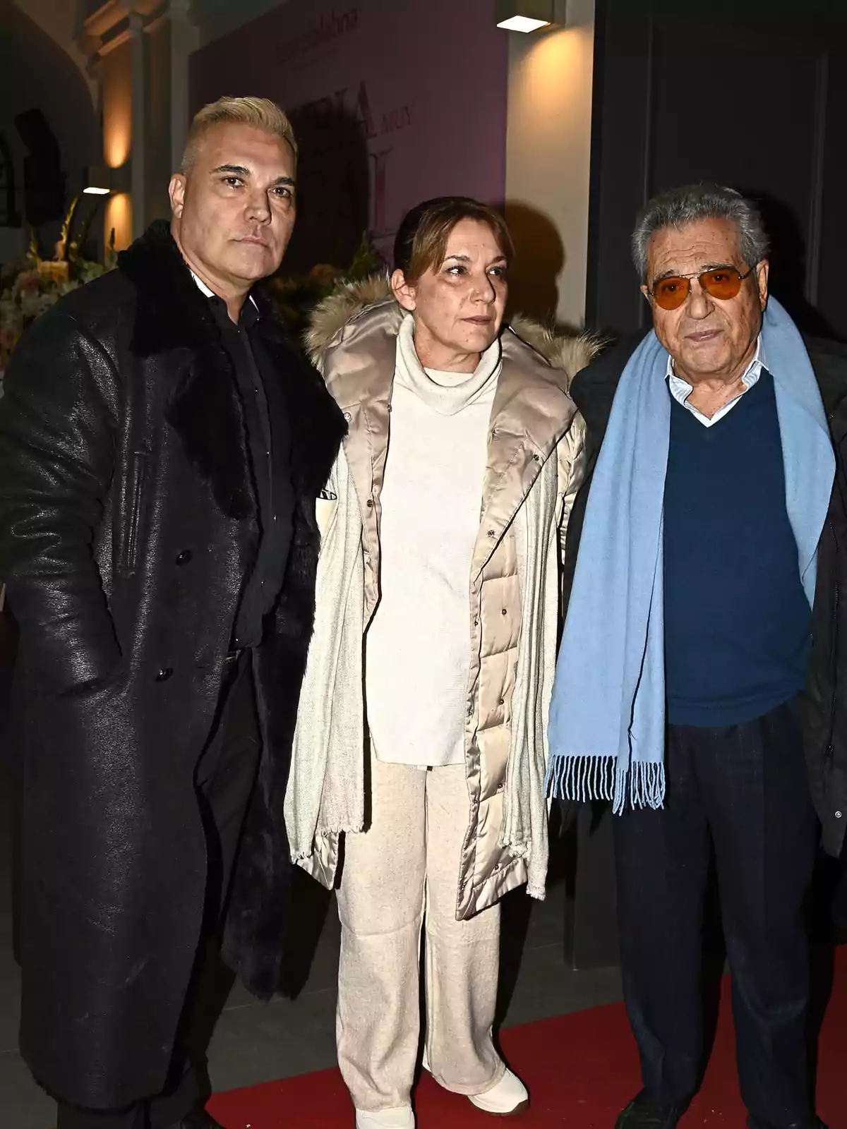 Tres personas posan juntas sobre una alfombra roja en un evento, todas vestidas con ropa de invierno Tres personas posan juntas sobre una alfombra roja en un evento, todas vestidas con ropa de invierno