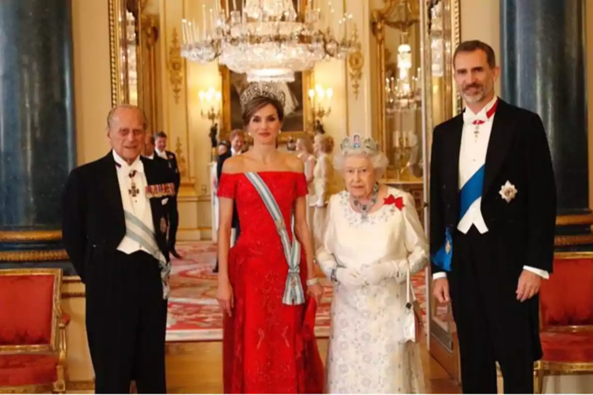 Four people dressed in formal attire pose in an elegant hall with chandeliers and gold decor. Four people dressed in formal attire pose in an elegant hall with chandeliers and gold decor.