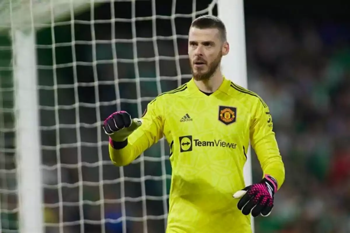 Portero del Manchester United con uniforme amarillo y guantes negros de pie frente a la portería durante un partido de fútbol Portero del Manchester United con uniforme amarillo y guantes negros de pie frente a la portería durante un partido de fútbol