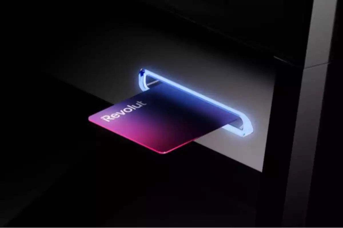 Tarjeta bancaria de Revolut siendo insertada en un cajero automático iluminado Tarjeta bancaria de Revolut siendo insertada en un cajero automático iluminado