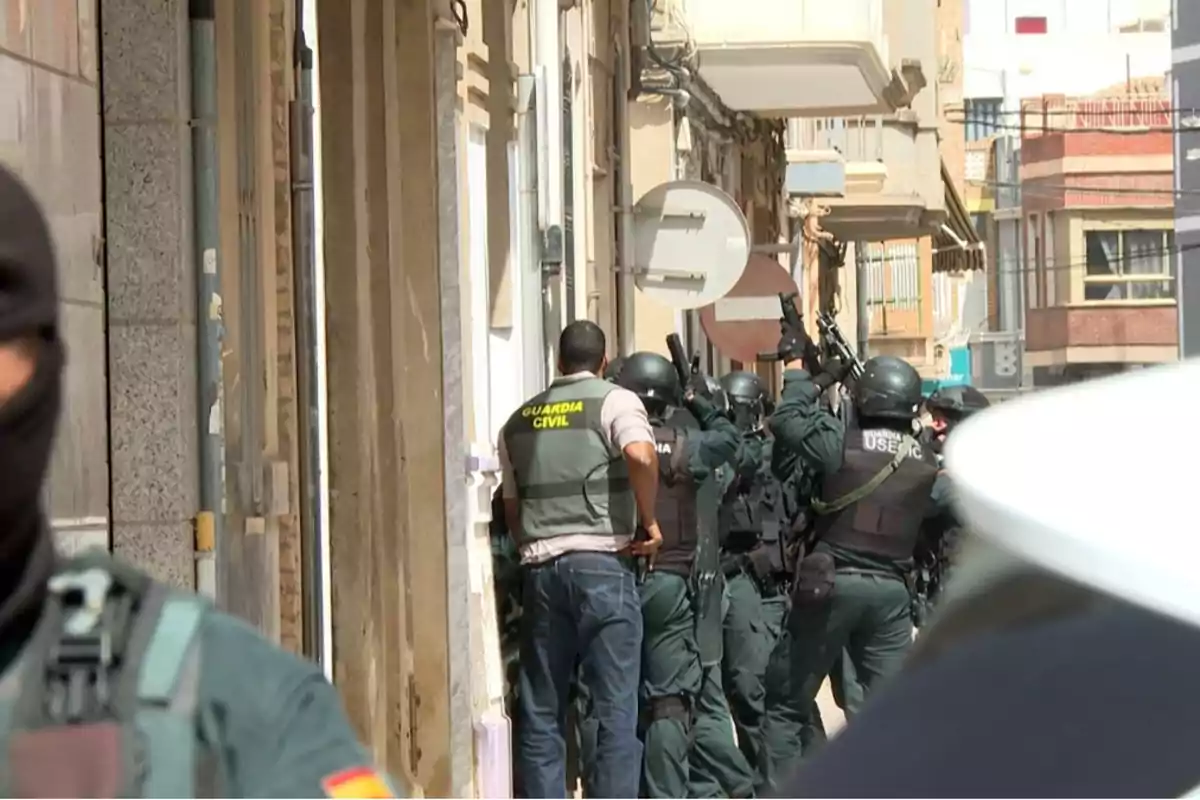 Agentes de la Guardia Civil fuertemente armados realizan un operativo en una calle urbana durante el día Agentes de la Guardia Civil fuertemente armados realizan un operativo en una calle urbana durante el día