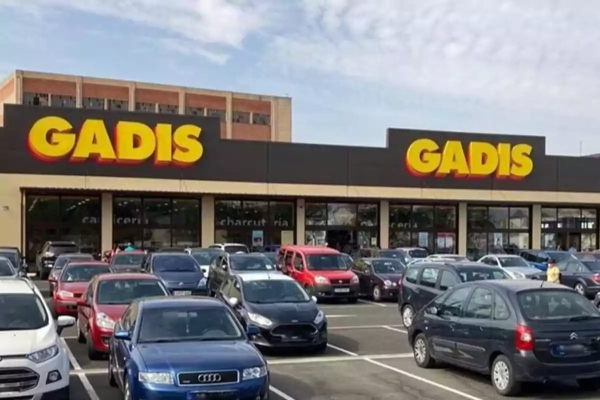Fachada de un supermercado Gadis con varios coches aparcados en el estacionamiento delantero Fachada de un supermercado Gadis con varios coches aparcados en el estacionamiento delantero