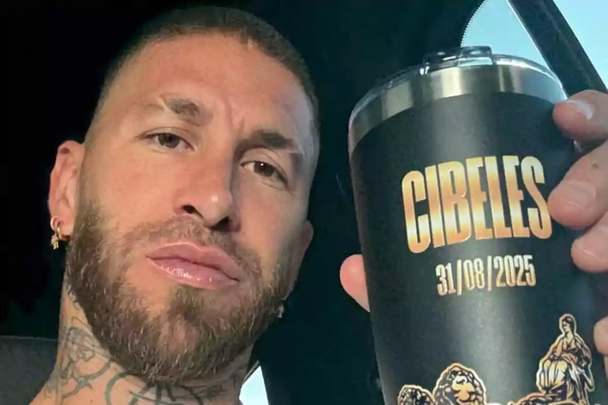 Hombre con barba y tatuajes sostiene un vaso negro que tiene la palabra Cibeles y la fecha 31 08 2025 impresas en letras doradas