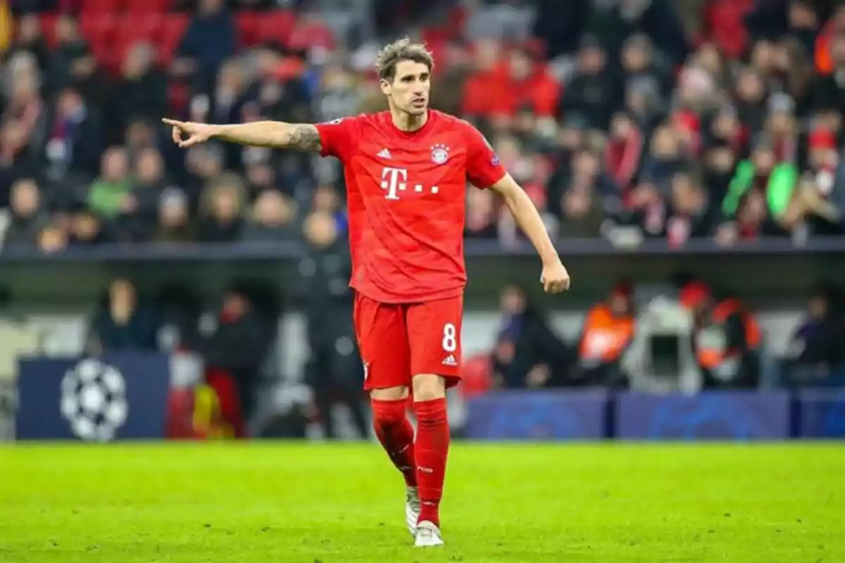 Futbolista con uniforme rojo del Bayern Múnich señalando con el brazo extendido en un estadio durante un partido Futbolista con uniforme rojo del Bayern Múnich señalando con el brazo extendido en un estadio durante un partido