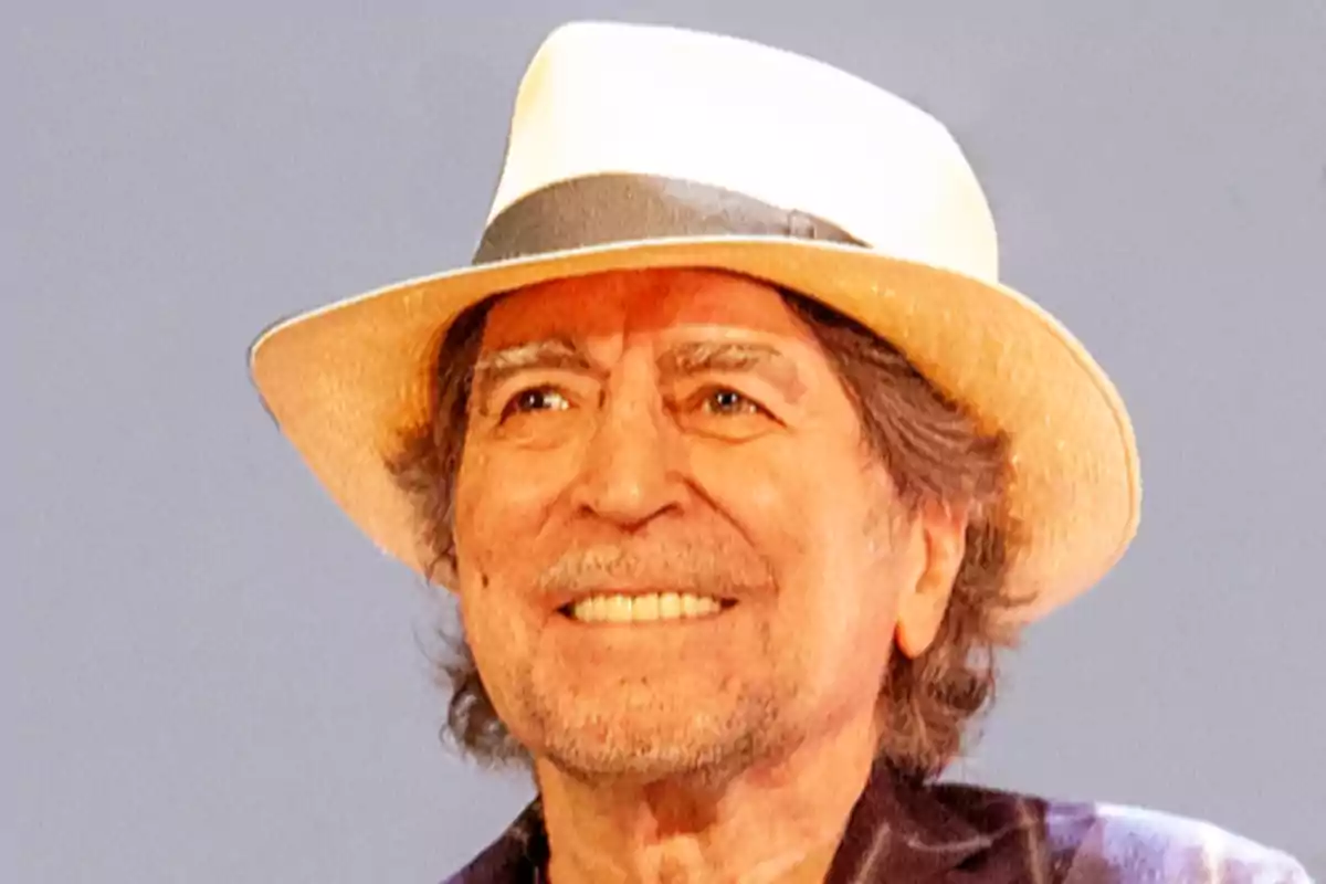 Hombre mayor sonriente con sombrero blanco y fondo gris Hombre mayor sonriente con sombrero blanco y fondo gris