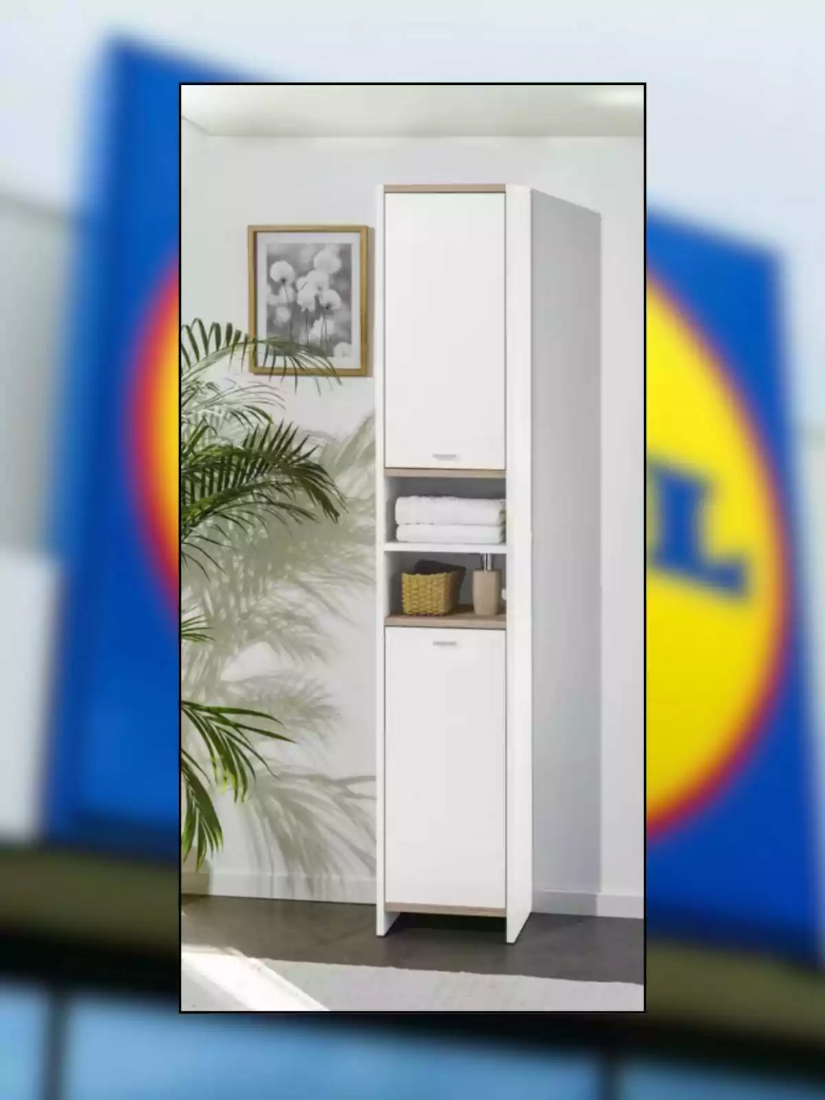 Mueble alto blanco con puertas y estantes, colocado junto a una planta y un cuadro decorativo en una habitación iluminada Mueble alto blanco con puertas y estantes, colocado junto a una planta y un cuadro decorativo en una habitación iluminada