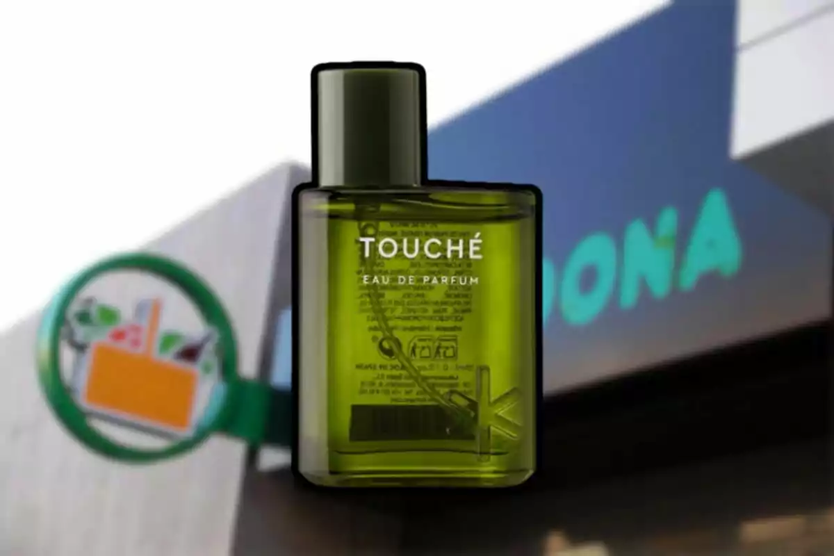 Un frasco de perfume verde con la palabra Touché al frente aparece sobre el fondo de una tienda Mercadona desenfocada. Un frasco de perfume verde con la palabra Touché al frente aparece sobre el fondo de una tienda Mercadona desenfocada.