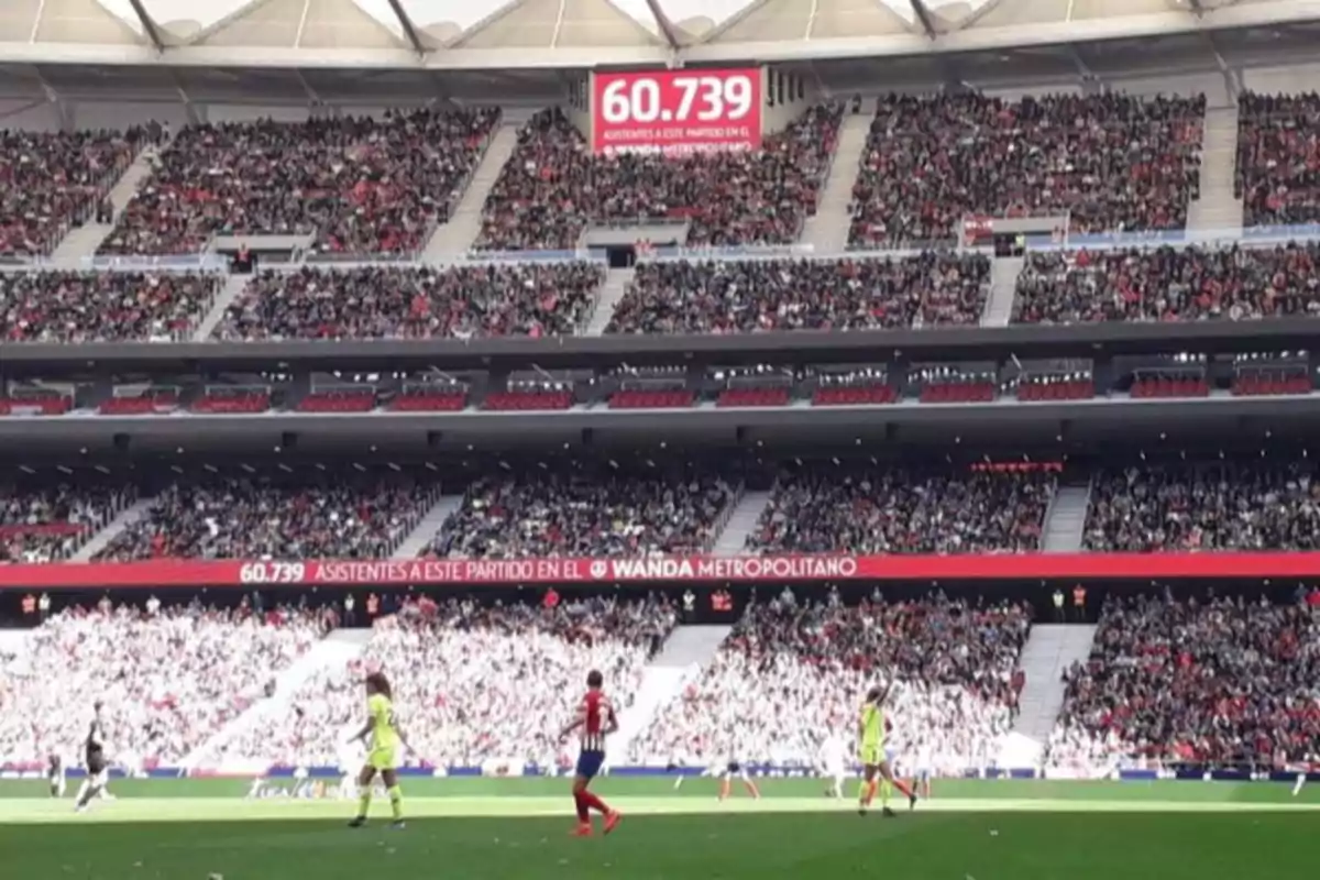 Estadio lleno de aficionados durante un partido de fútbol con un marcador que muestra la asistencia de 60,739 personas Estadio lleno de aficionados durante un partido de fútbol con un marcador que muestra la asistencia de 60,739 personas