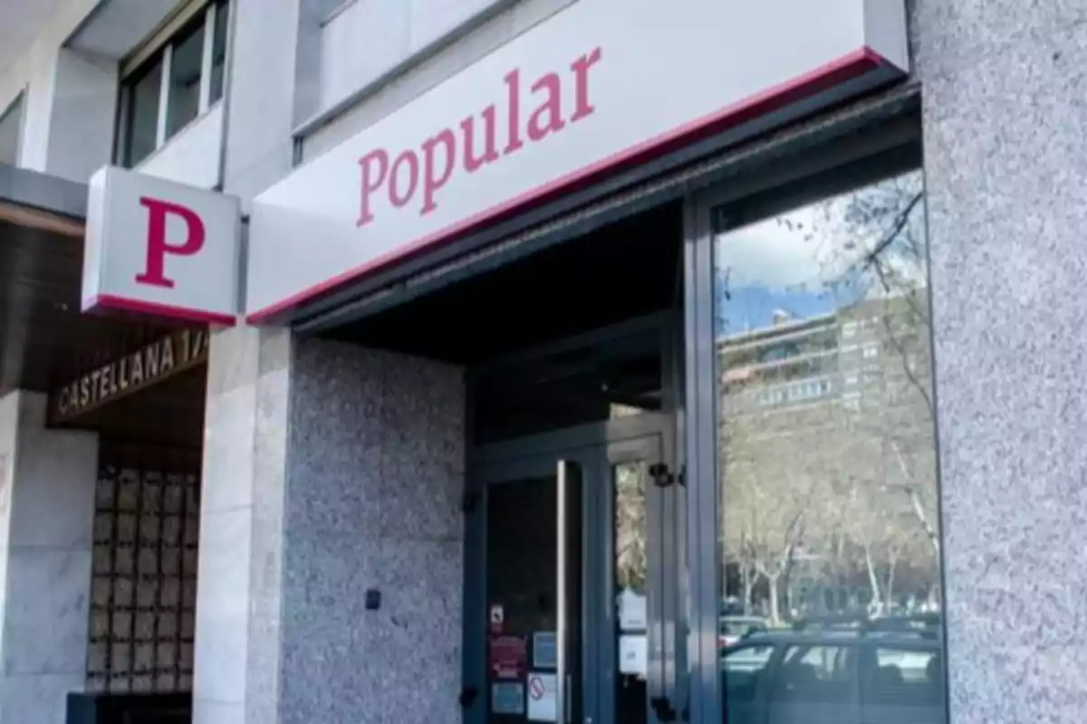 Fachada de una sucursal del banco Popular en una calle urbana Fachada de una sucursal del banco Popular en una calle urbana