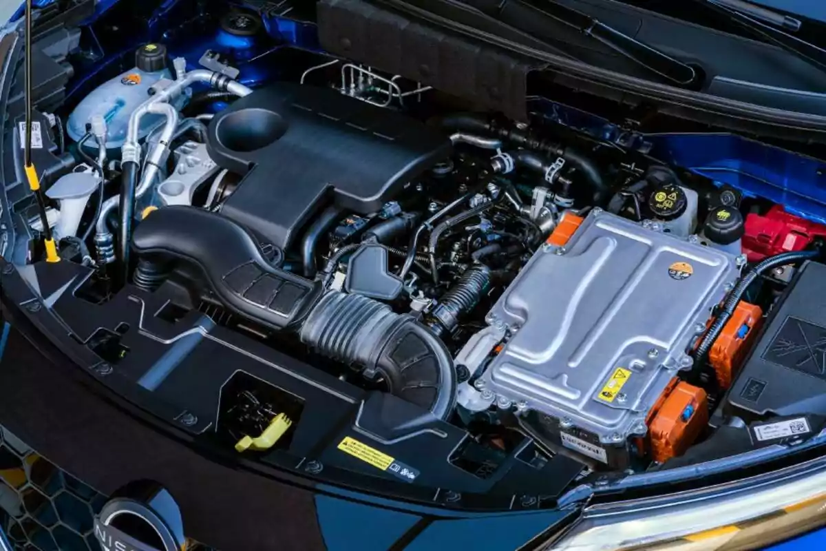 Vista del motor de un automóvil moderno con componentes eléctricos y mecánicos visibles bajo el cofre Vista del motor de un automóvil moderno con componentes eléctricos y mecánicos visibles bajo el cofre