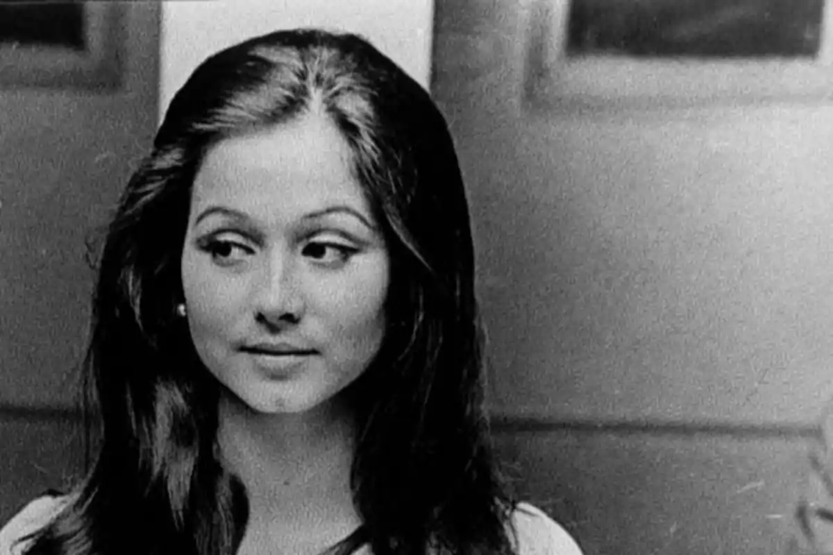 Mujer joven de cabello largo y oscuro mirando hacia un lado en una fotografía en blanco y negro Mujer joven de cabello largo y oscuro mirando hacia un lado en una fotografía en blanco y negro