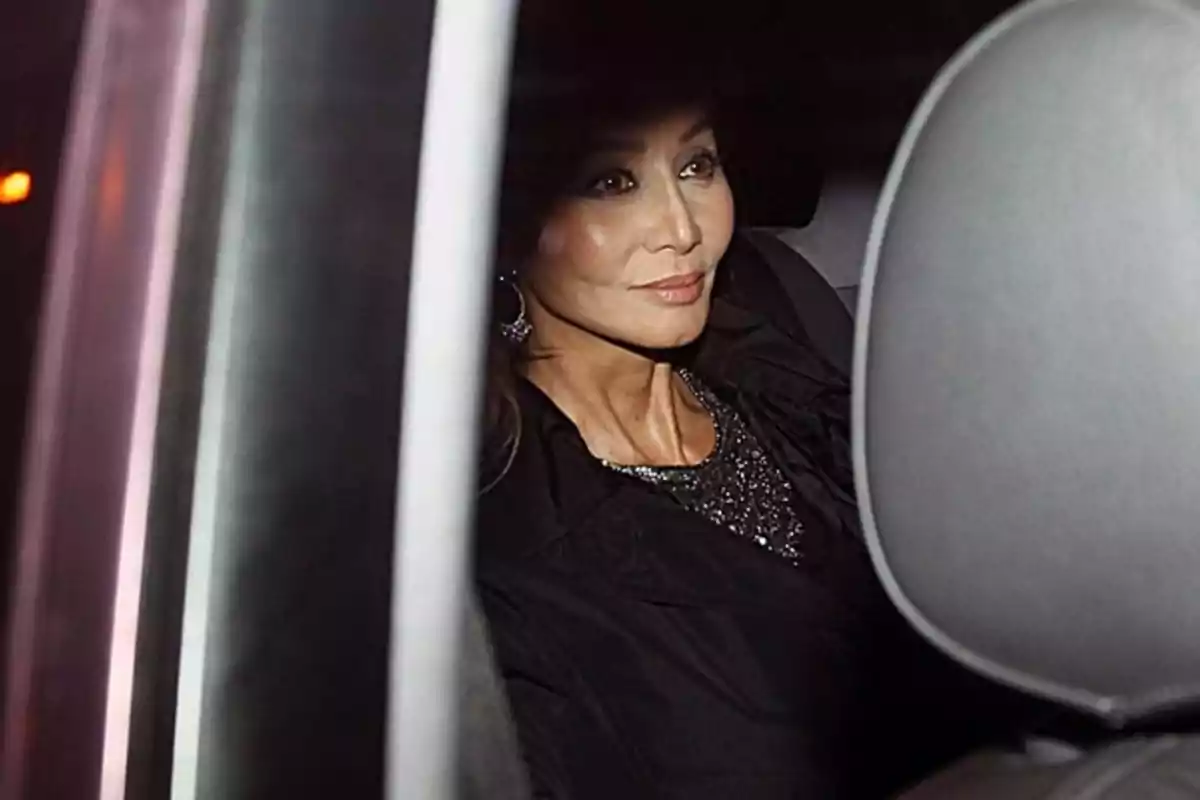 Mujer sentada en el asiento trasero de un automóvil mirando hacia la ventana