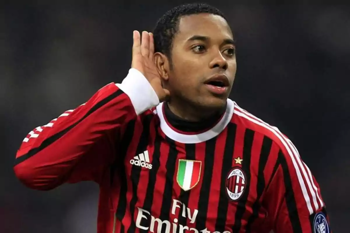 Futbolista con uniforme del AC Milan celebrando un gol con la mano en la oreja Futbolista con uniforme del AC Milan celebrando un gol con la mano en la oreja