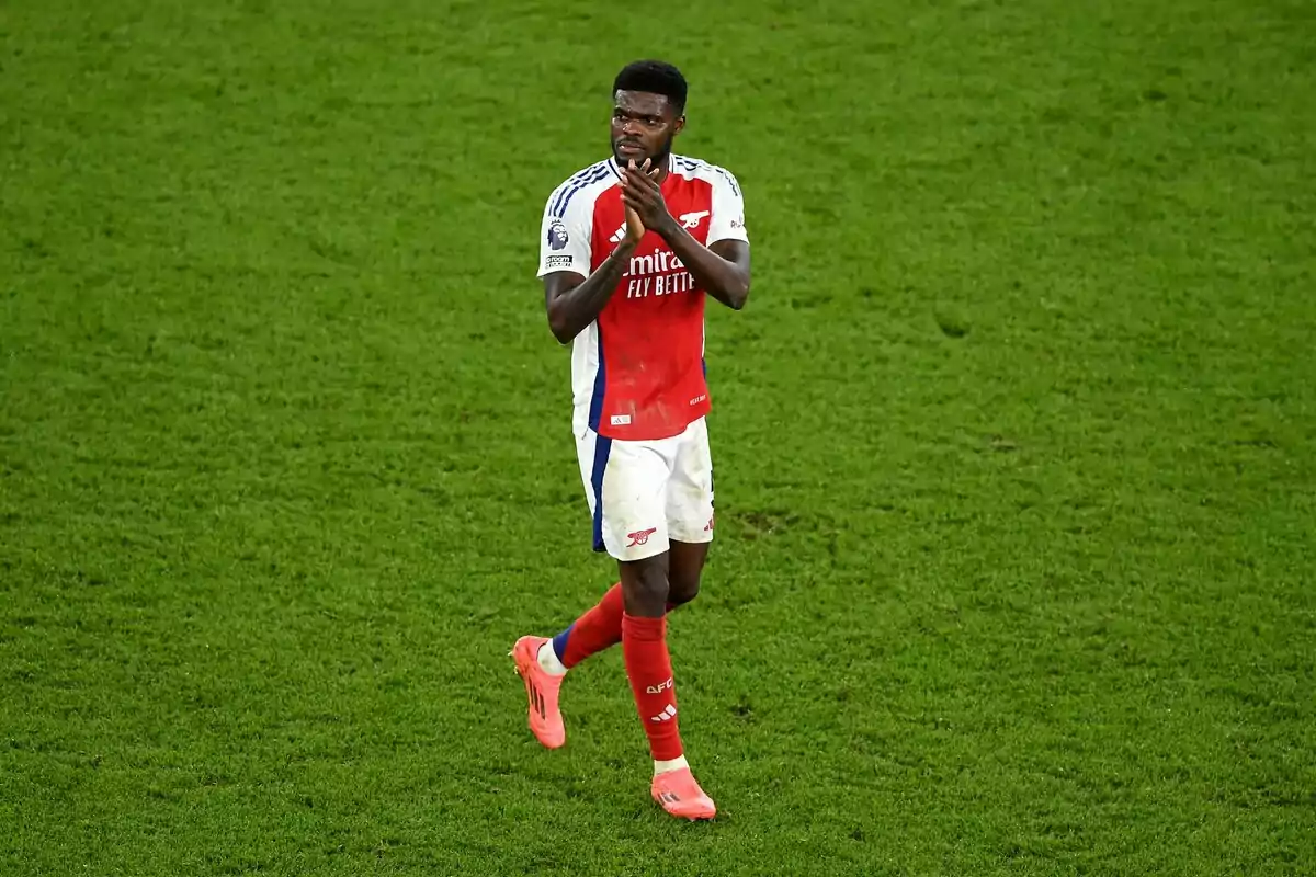 Futbolista del Arsenal aplaudiendo sobre el césped durante un partido Futbolista del Arsenal aplaudiendo sobre el césped durante un partido