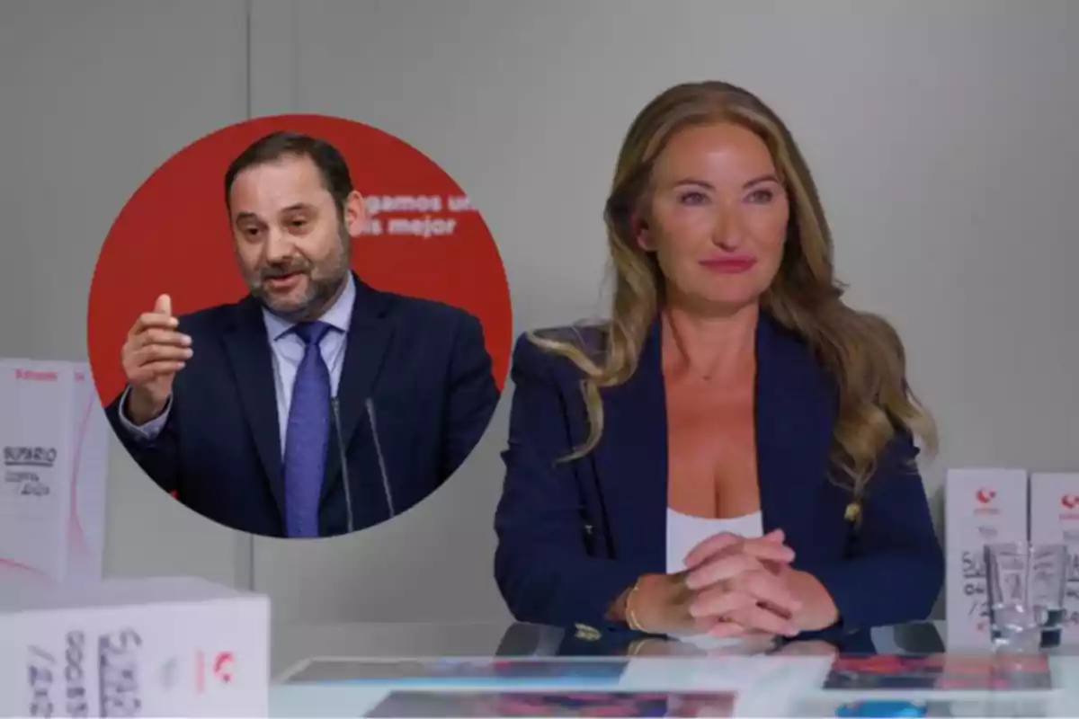 Una mujer sentada en una mesa con las manos entrelazadas y al fondo un recuadro con la imagen de un hombre hablando en público