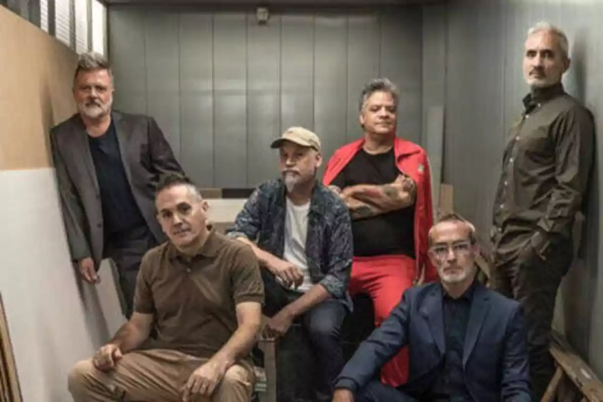 Seis hombres posando en una habitación con paredes metálicas.