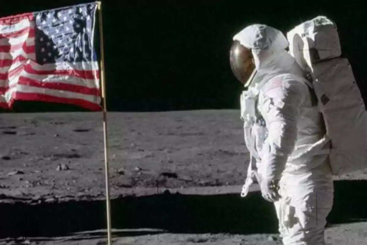 Astronauta en la luna junto a una bandera de Estados Unidos.