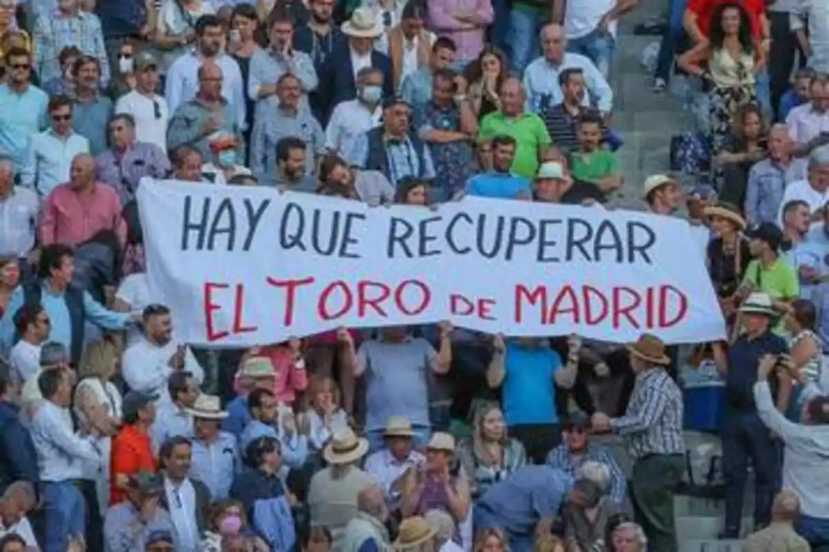 Un grupo de personas en una multitud sostiene una pancarta que dice 