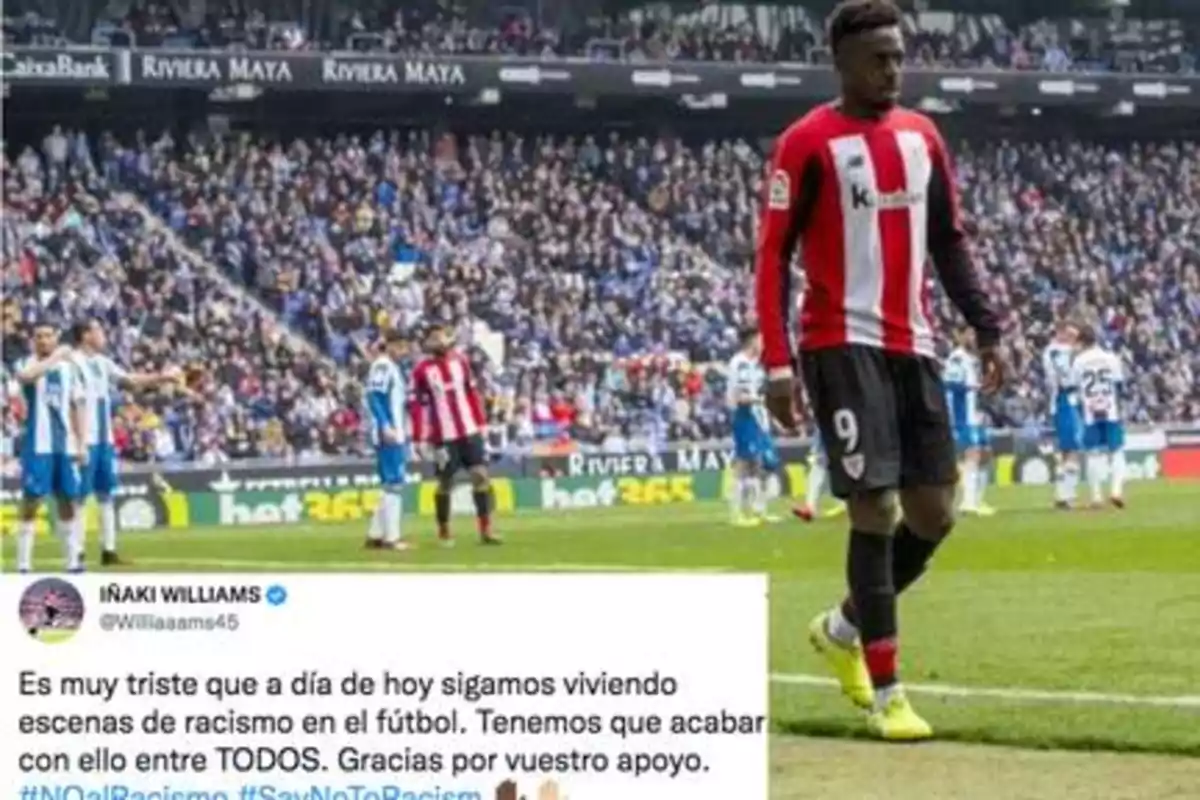 Un jugador de fútbol del Athletic Club camina cabizbajo en el campo mientras se observa un mensaje en redes sociales denunciando el racismo en el deporte.