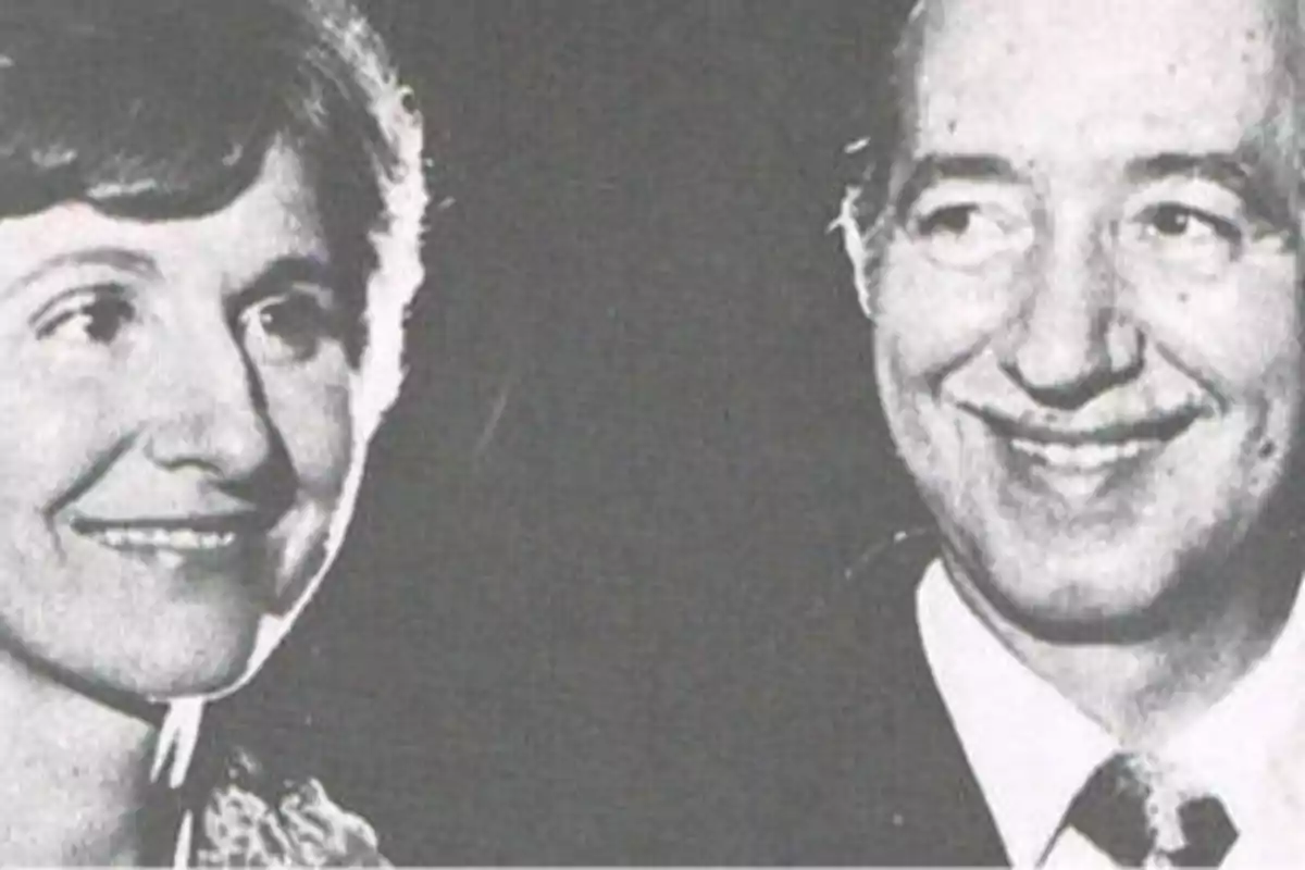 Una pareja sonriente en una fotografía en blanco y negro.