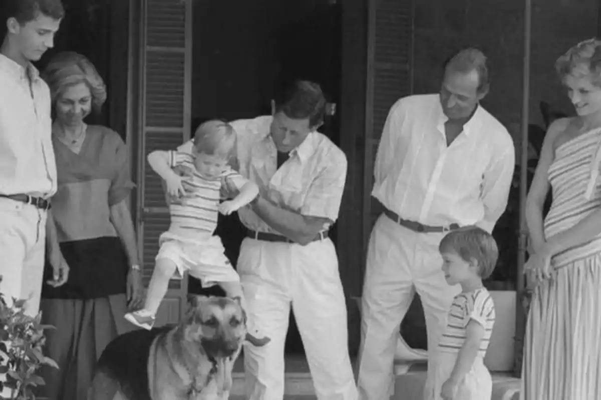 Un grupo de personas, incluyendo a dos niños, un perro y cinco adultos, posan juntos en una fotografía en blanco y negro.