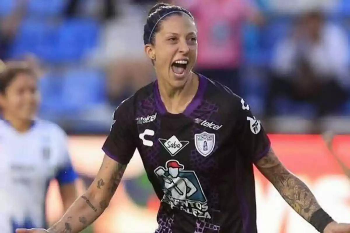 Una jugadora de fútbol celebra en el campo con la camiseta del equipo Pachuca.