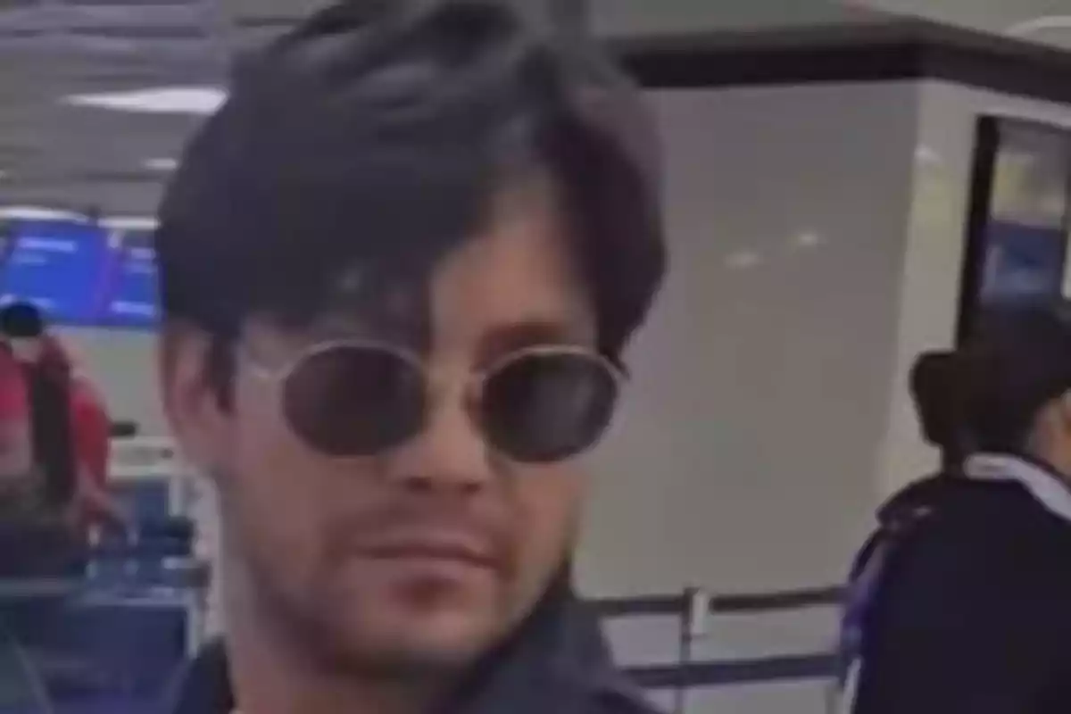 Hombre con gafas de sol en un aeropuerto.