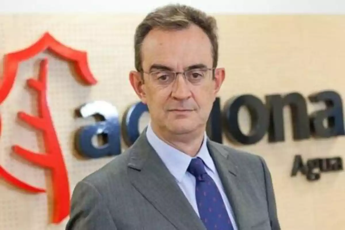 Hombre con traje y corbata frente a un logotipo de la empresa Acciona.