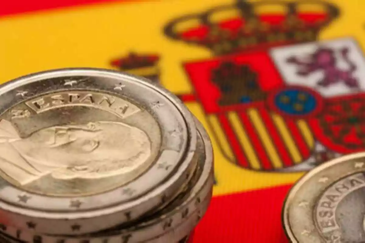Imagen de monedas de Euro con la bandera de España de fondo