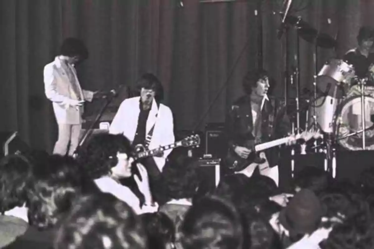 Una banda de rock tocando en vivo frente a una audiencia.