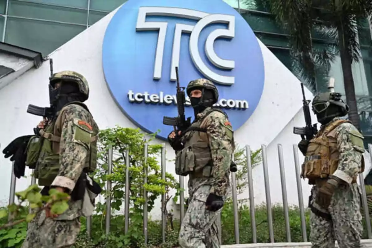 Soldados armados con equipo táctico frente a un edificio con el logo de TC Televisión.