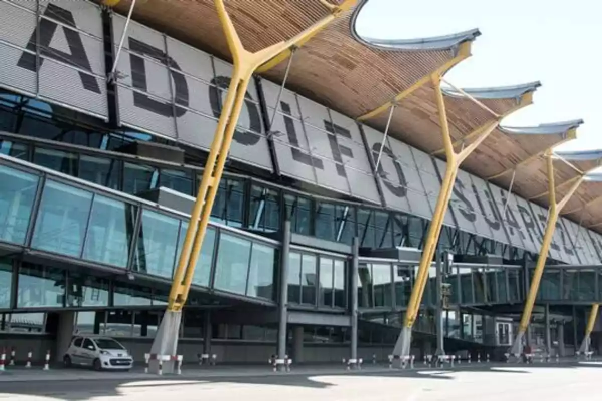 Fachada del Aeropuerto Adolfo Suárez Madrid-Barajas con estructura moderna y columnas amarillas.